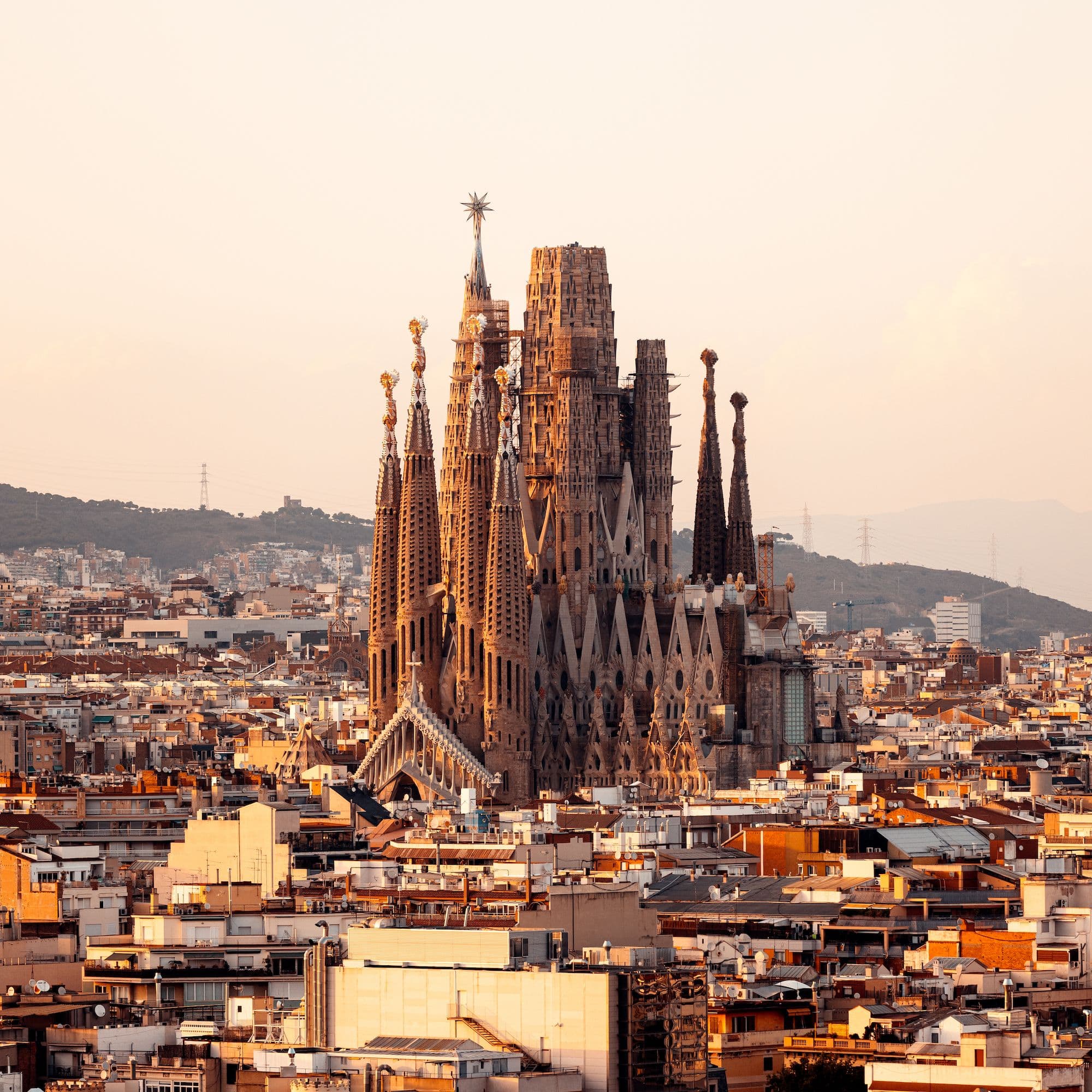 Golden afternoon sunlight shining through orange stained glass windows inside Sagrada Familia